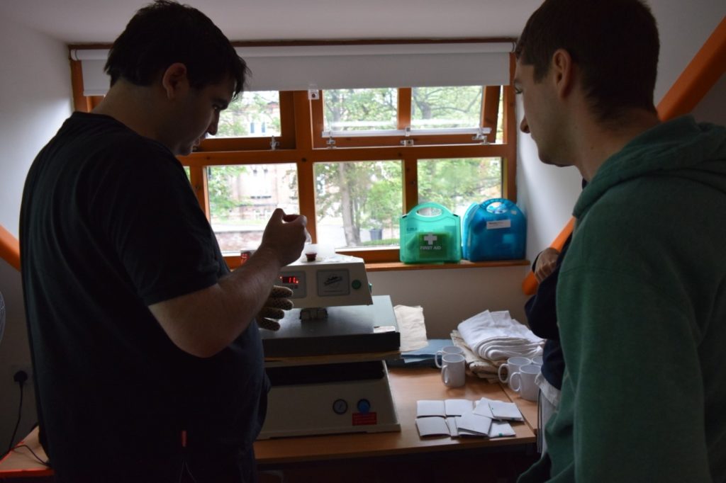 Two male students getting ready to print a t-shirt 