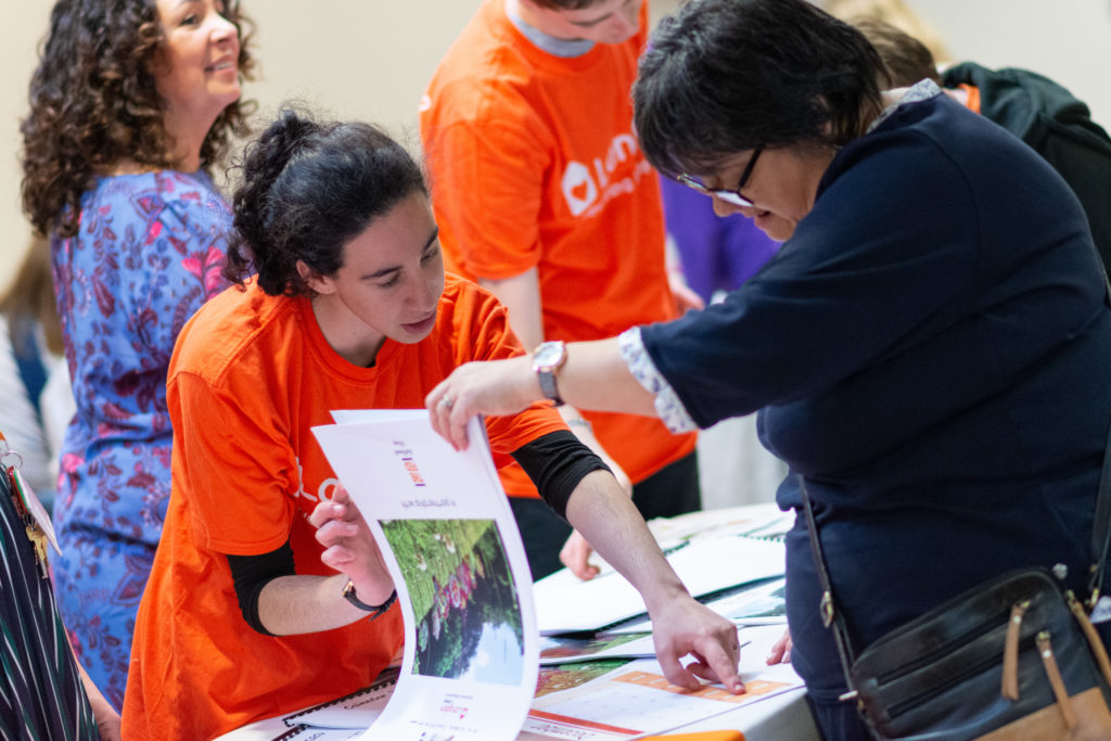 Langdon College student showing a customer the calendar they produced.  