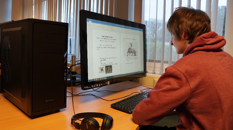 Student sitting in front of newly upgraded computer 