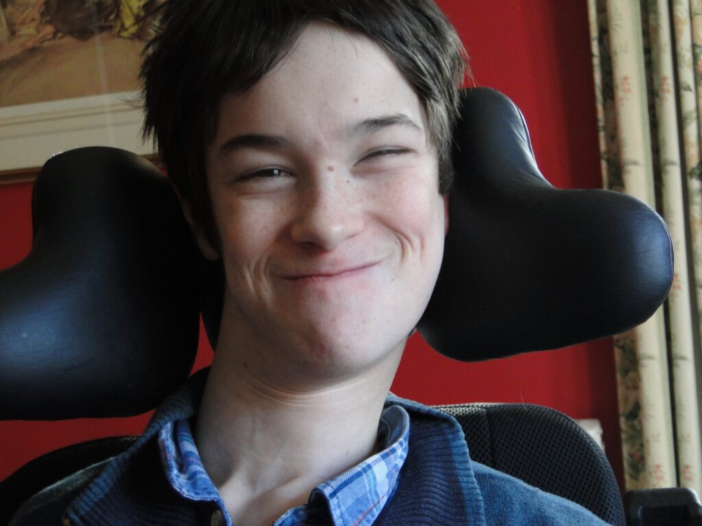 Oscar sitting in his wheelchair and smiling