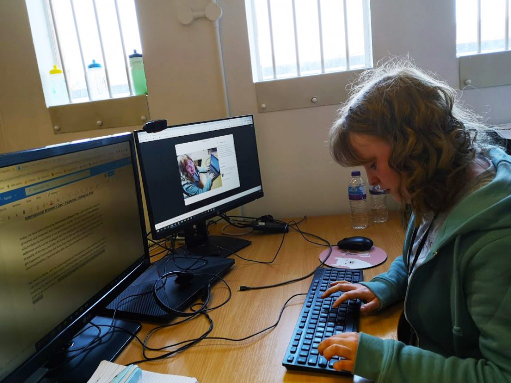 Finola sitting at a desk and working on social media posts