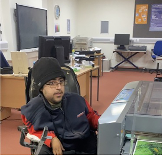 Hashim, sitting in his wheelchair in TreloarPrint Karten Centre