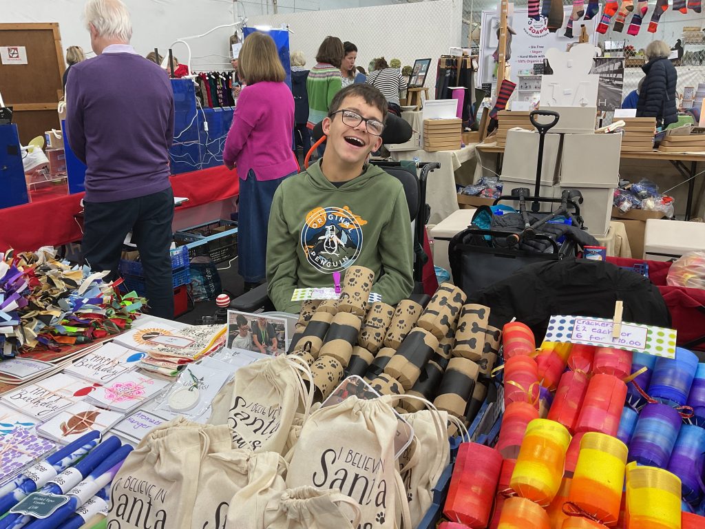 Ben, a young man sitting at the Treloar stall at at Dummer Fair. 