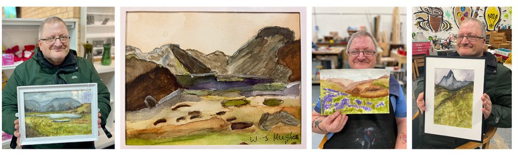 Bill, a middle aged man with glasses, holding up his landscape paintings.  